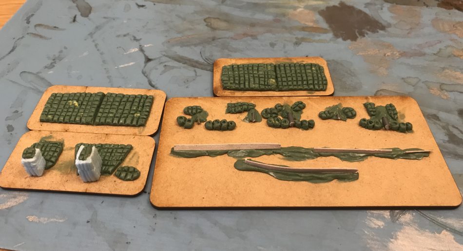 The siege lines are made in greenstuff. The wooden palisades are simple packaging card and the cannons are made from wire and a plastic spear. 
